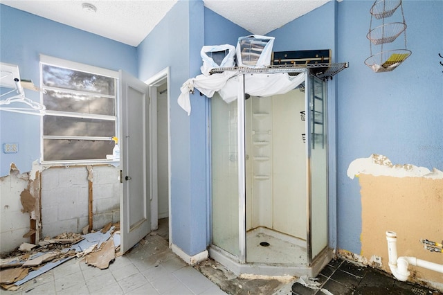 bathroom with a textured ceiling and walk in shower