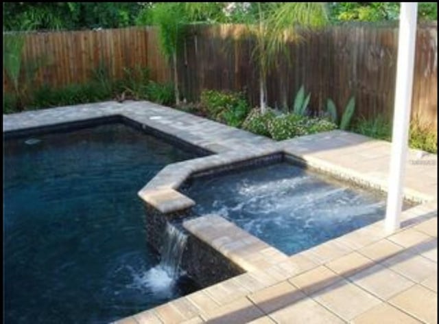 view of pool featuring an in ground hot tub