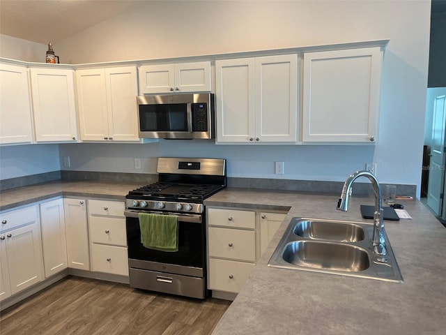 kitchen featuring sink, white cabinets, stainless steel appliances, and vaulted ceiling