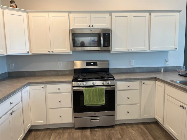 kitchen with white cabinets, stainless steel appliances, and dark wood-type flooring