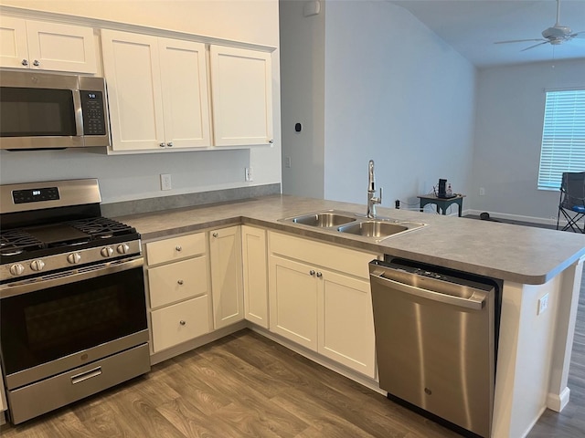 kitchen with kitchen peninsula, appliances with stainless steel finishes, white cabinetry, and sink