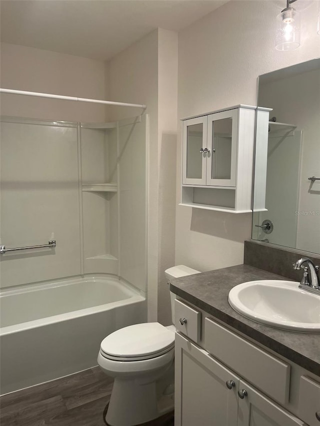 full bathroom with shower / bathing tub combination, vanity, wood-type flooring, and toilet