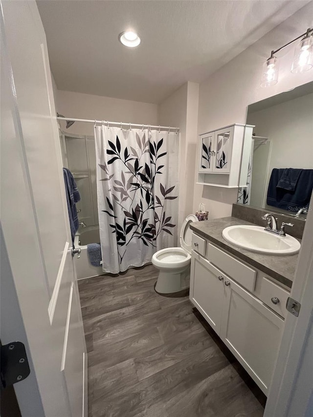 full bathroom with hardwood / wood-style flooring, shower / bath combination with curtain, toilet, and vanity