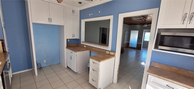 kitchen featuring light tile patterned flooring, ceiling fan, white cabinets, and wooden ceiling