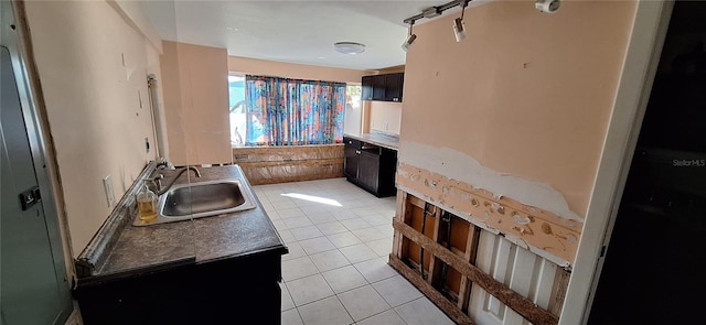 kitchen featuring sink, light tile patterned floors, and dark brown cabinets