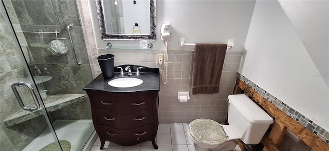 bathroom featuring tile patterned flooring, a shower with door, tile walls, and toilet