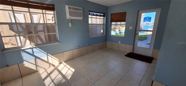 entrance foyer featuring a wall mounted air conditioner and tile patterned floors