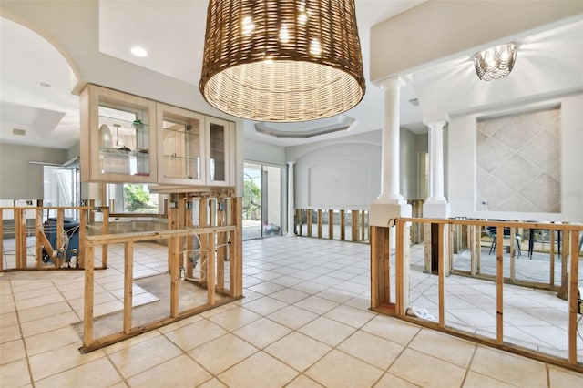 interior space featuring ornate columns and light tile patterned floors