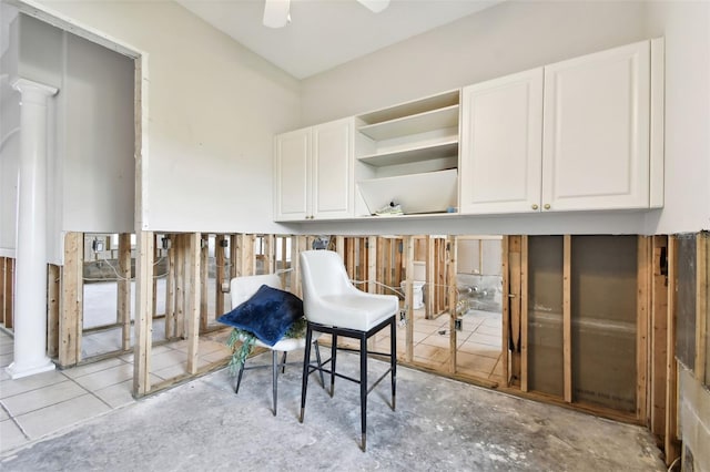 interior space with ceiling fan and decorative columns