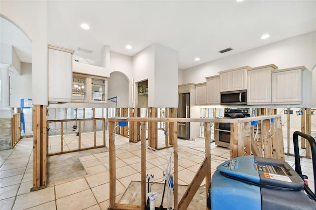 kitchen featuring cream cabinets, stainless steel appliances, and light tile patterned floors