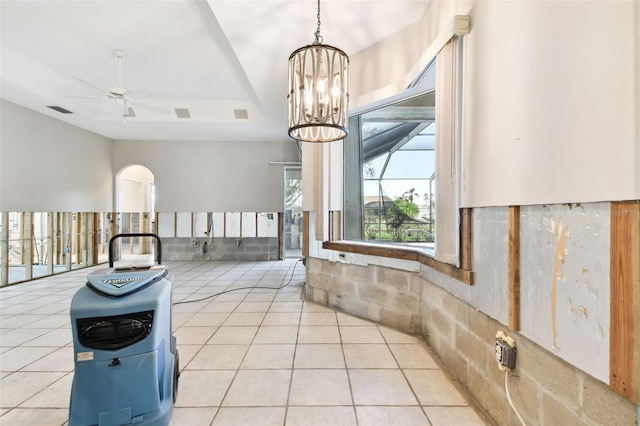 tiled foyer featuring ceiling fan with notable chandelier