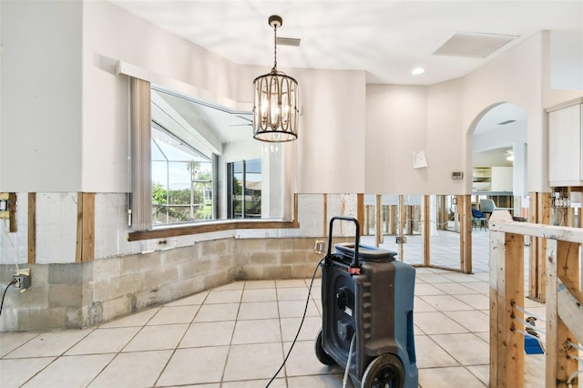 kitchen with a notable chandelier, decorative light fixtures, white cabinetry, and light tile patterned floors