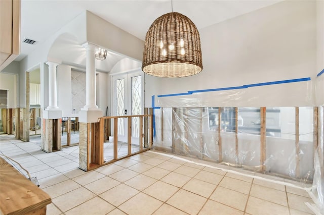 interior space featuring light tile patterned flooring, french doors, and ornate columns