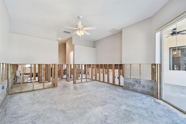 spare room featuring concrete flooring, ceiling fan with notable chandelier, and a wealth of natural light