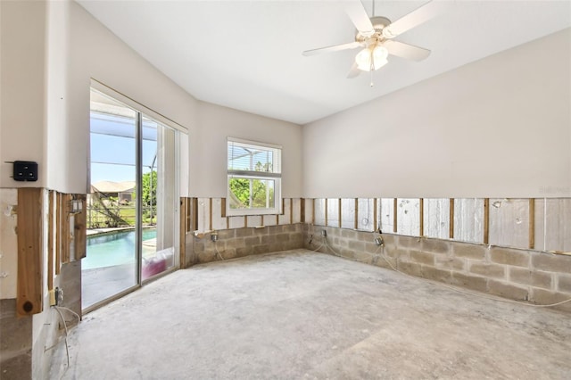 empty room with ceiling fan and concrete flooring