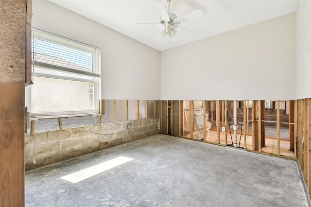 unfurnished room featuring ceiling fan and concrete flooring