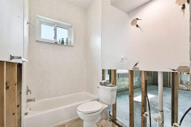 bathroom featuring tiled shower / bath combo and toilet