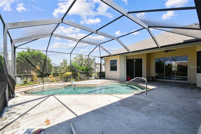 view of swimming pool featuring glass enclosure and a patio area