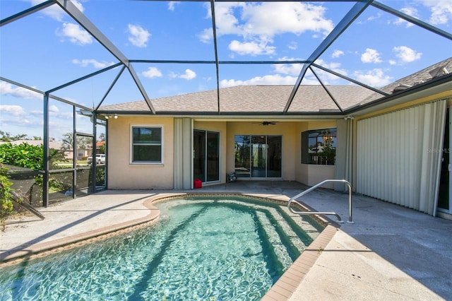 view of pool with a patio, glass enclosure, and ceiling fan