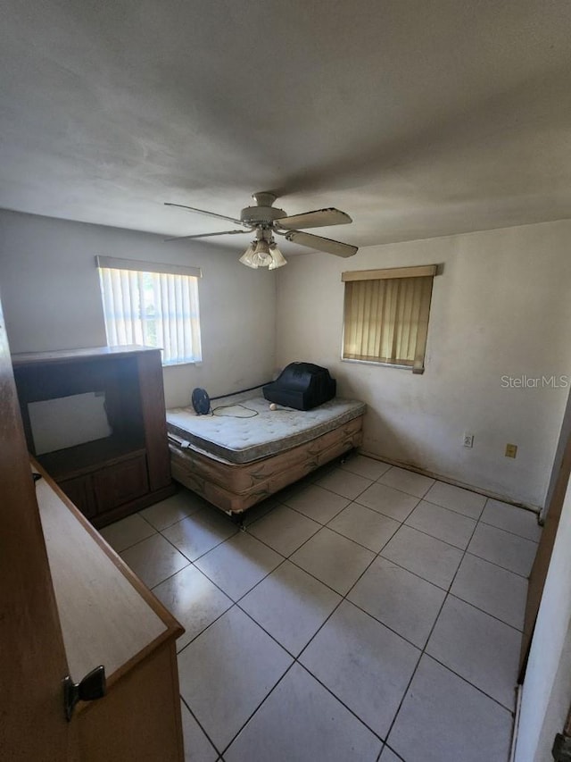 unfurnished bedroom with ceiling fan and light tile patterned floors