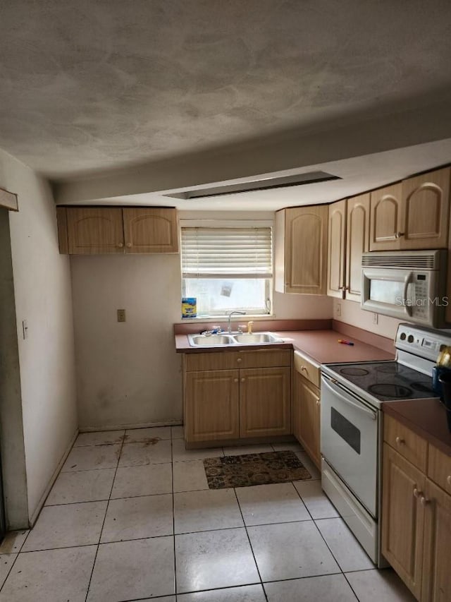 kitchen featuring light tile patterned floors, sink, and white appliances