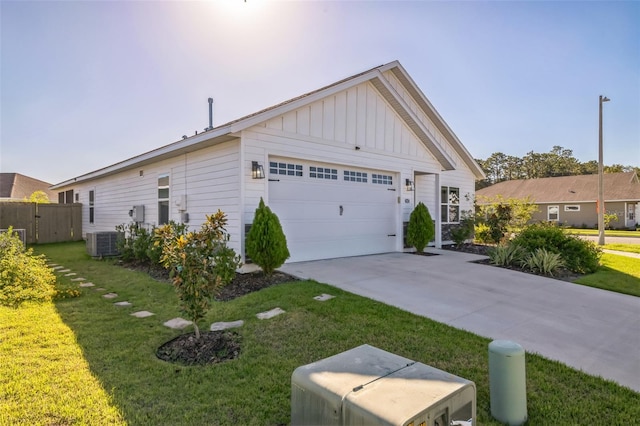 view of front of house featuring a garage, a front yard, and central AC unit