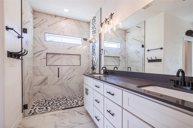 bathroom featuring a healthy amount of sunlight, a shower with door, and vanity