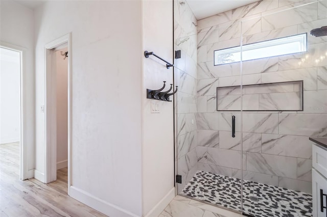 bathroom with hardwood / wood-style flooring, a shower with door, and vanity