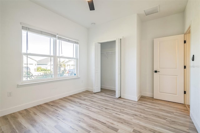 unfurnished bedroom featuring light wood-type flooring, ceiling fan, and a closet