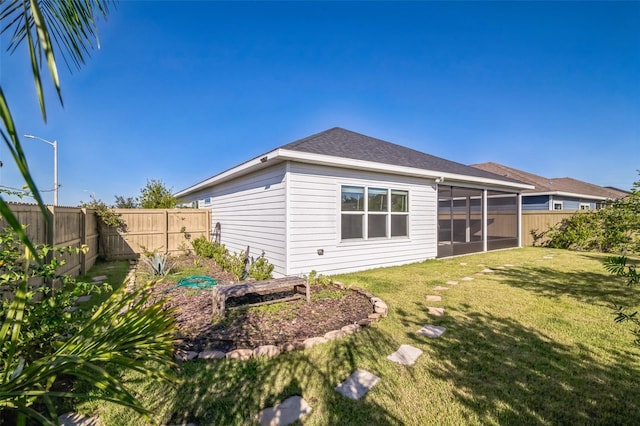 rear view of house with a yard and a sunroom