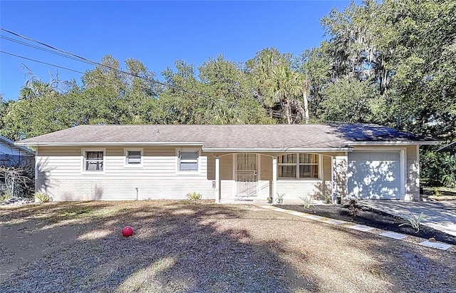 ranch-style home featuring covered porch and a garage