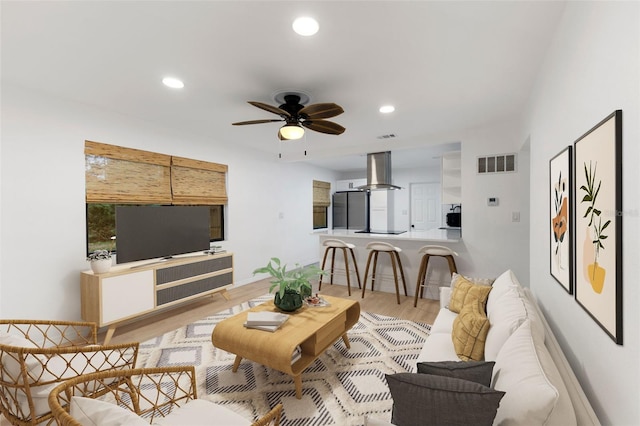 living room featuring ceiling fan and light wood-type flooring