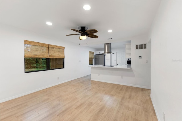 unfurnished living room with ceiling fan and light hardwood / wood-style floors