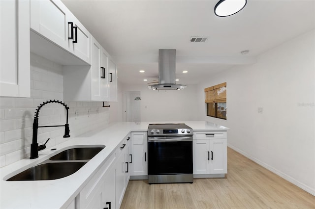 kitchen featuring island range hood, kitchen peninsula, decorative backsplash, stainless steel electric stove, and sink