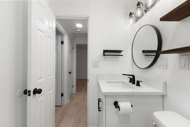 bathroom featuring toilet, hardwood / wood-style floors, and vanity