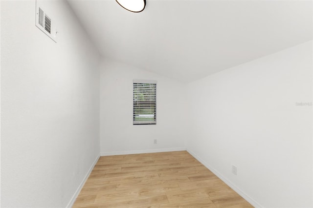 empty room featuring light hardwood / wood-style floors and vaulted ceiling