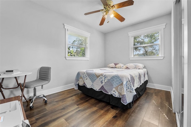 bedroom with dark wood-type flooring, multiple windows, and ceiling fan