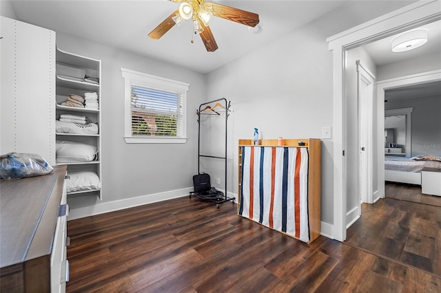 walk in closet with ceiling fan and dark hardwood / wood-style floors