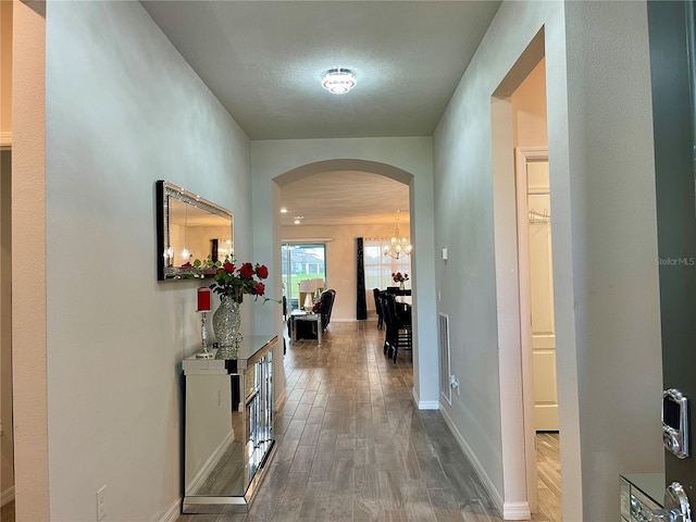 hall with wood-type flooring and a textured ceiling