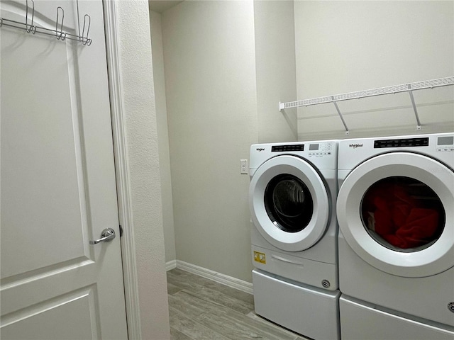 washroom with light hardwood / wood-style floors and separate washer and dryer