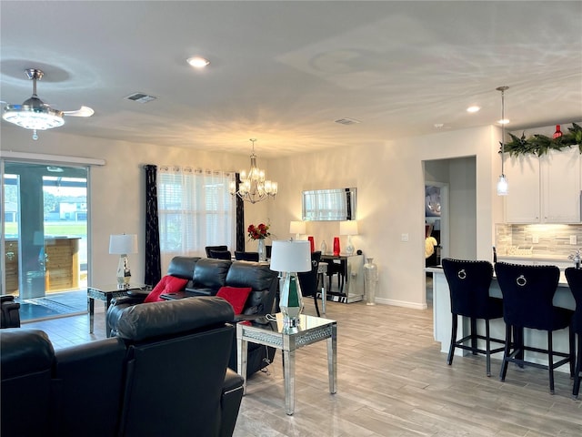 living room with a chandelier and light hardwood / wood-style floors