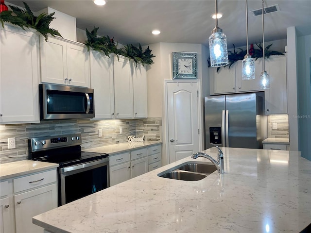 kitchen featuring light stone countertops, appliances with stainless steel finishes, sink, and white cabinetry