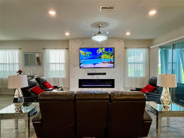 living room featuring a premium fireplace and a wealth of natural light