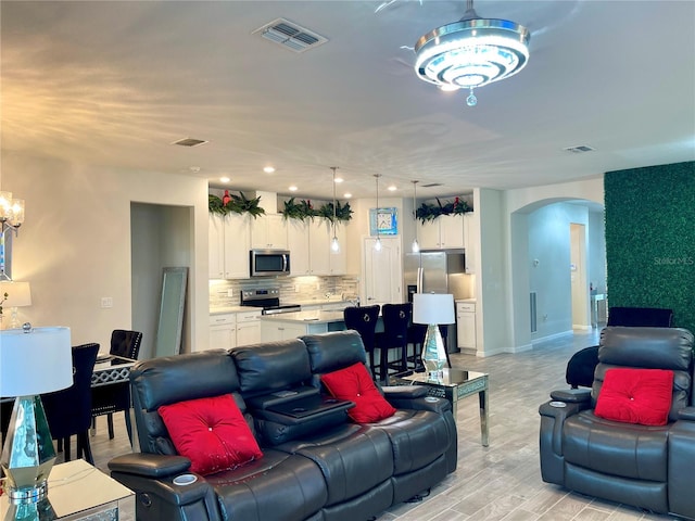 living room featuring an inviting chandelier and light wood-type flooring