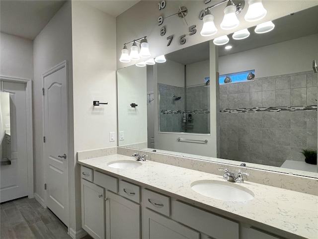 bathroom with hardwood / wood-style flooring, a tile shower, and vanity