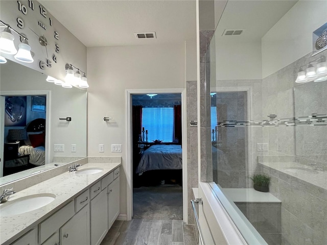 bathroom featuring hardwood / wood-style flooring, vanity, and tiled shower