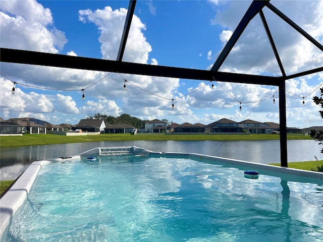 view of pool with glass enclosure and a water view