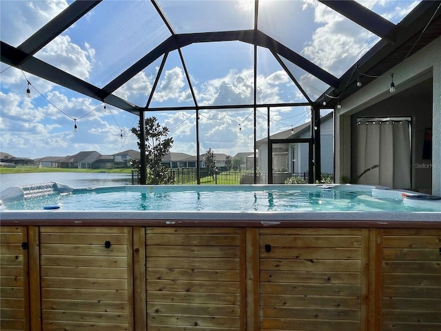 view of pool featuring a lanai and a hot tub