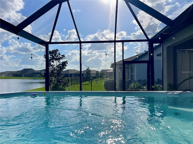 view of swimming pool with a water view and a lanai