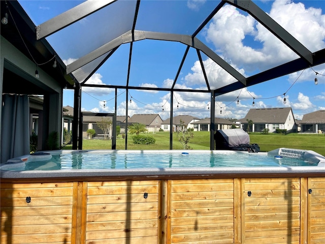 view of swimming pool with area for grilling, a lawn, and a lanai